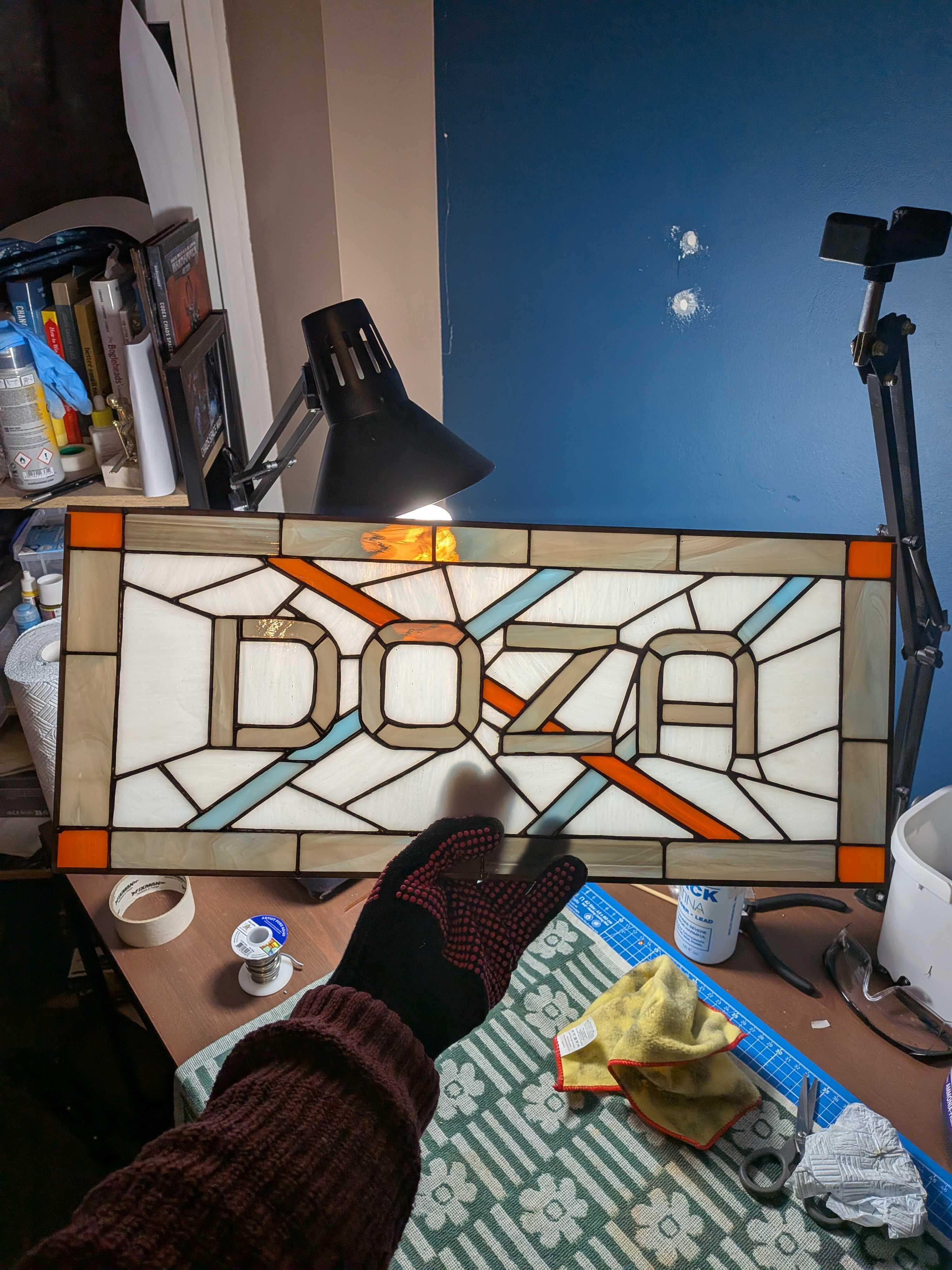 Stained glass business sign reading Doza